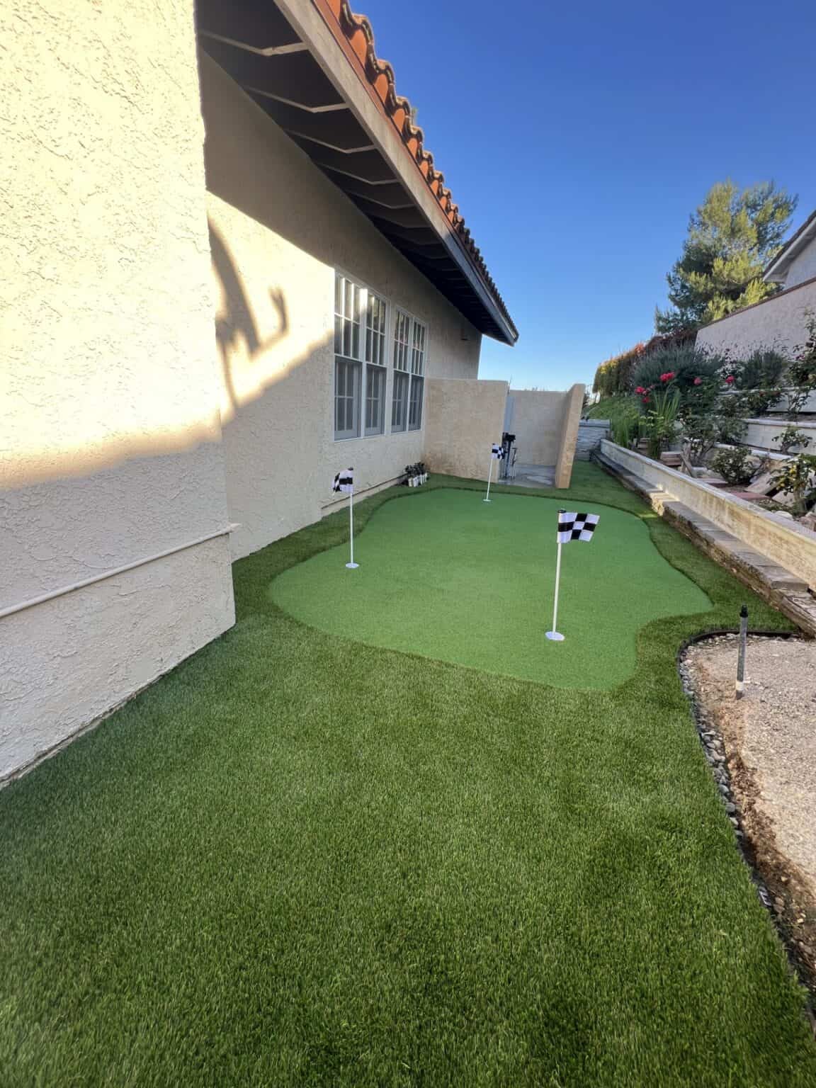 Backyard with new artificial turf and a paver patio after installation