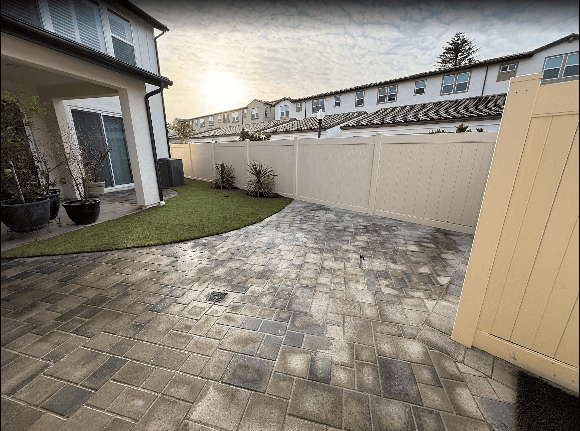 Backyard remodel with artificial turf, hardscape borders, and a seating area