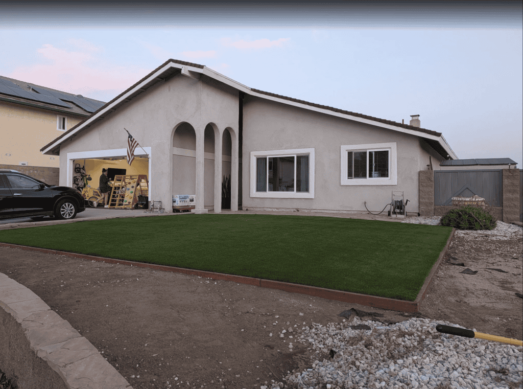 A front yard before the remodel, with worn lawn and bare dirt