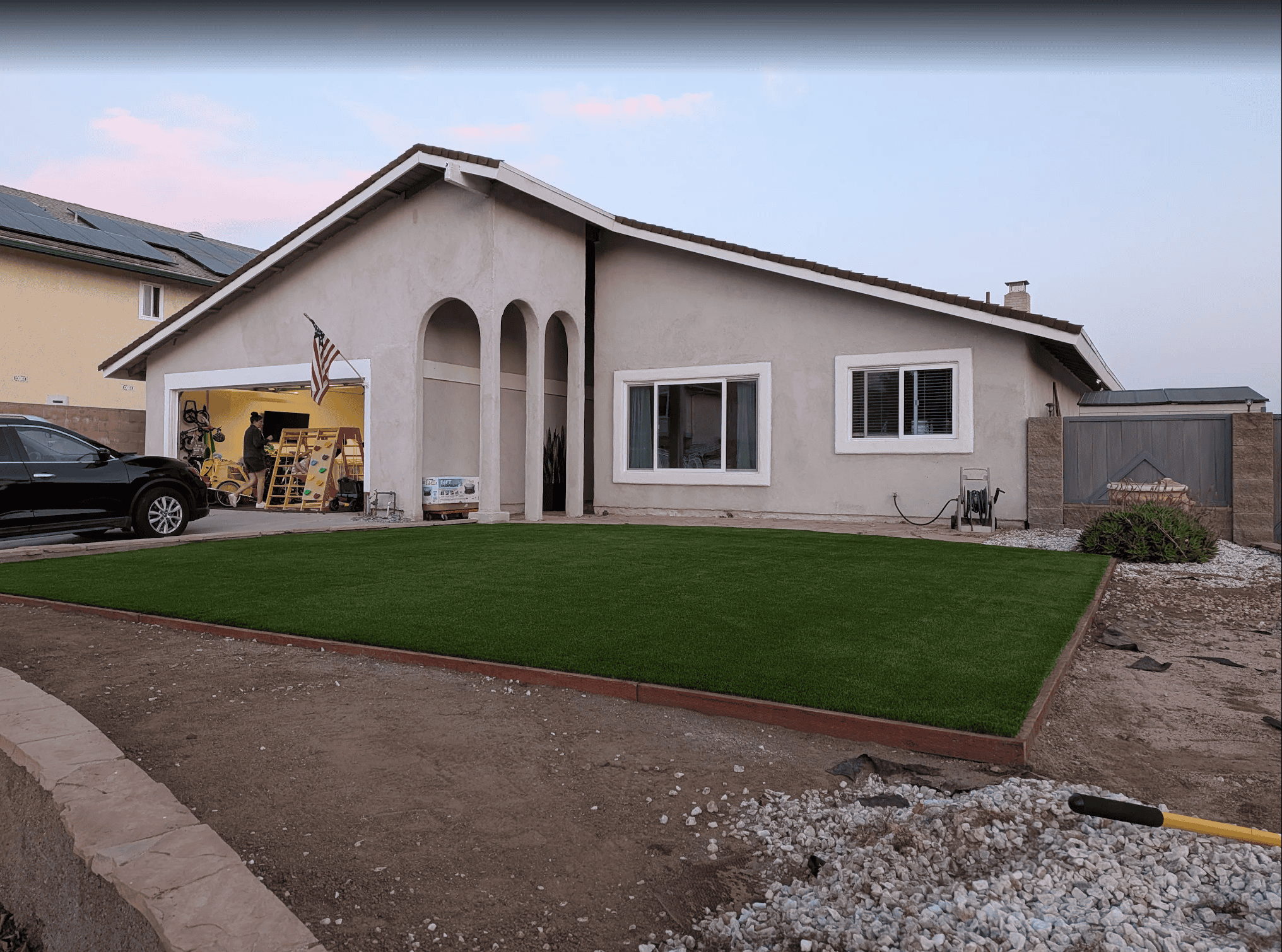 A front yard before the remodel, with worn lawn and bare dirt