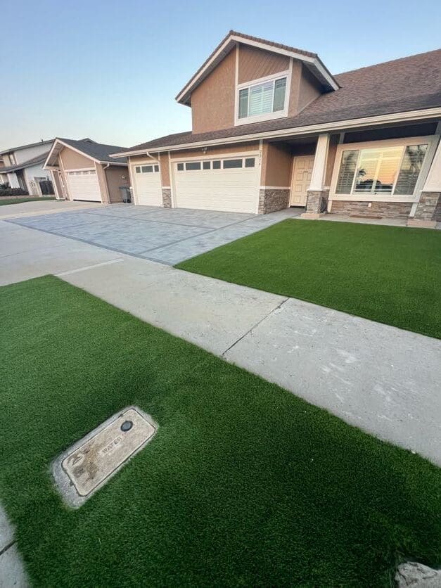 Same front yard after paver driveway and artificial turf installation